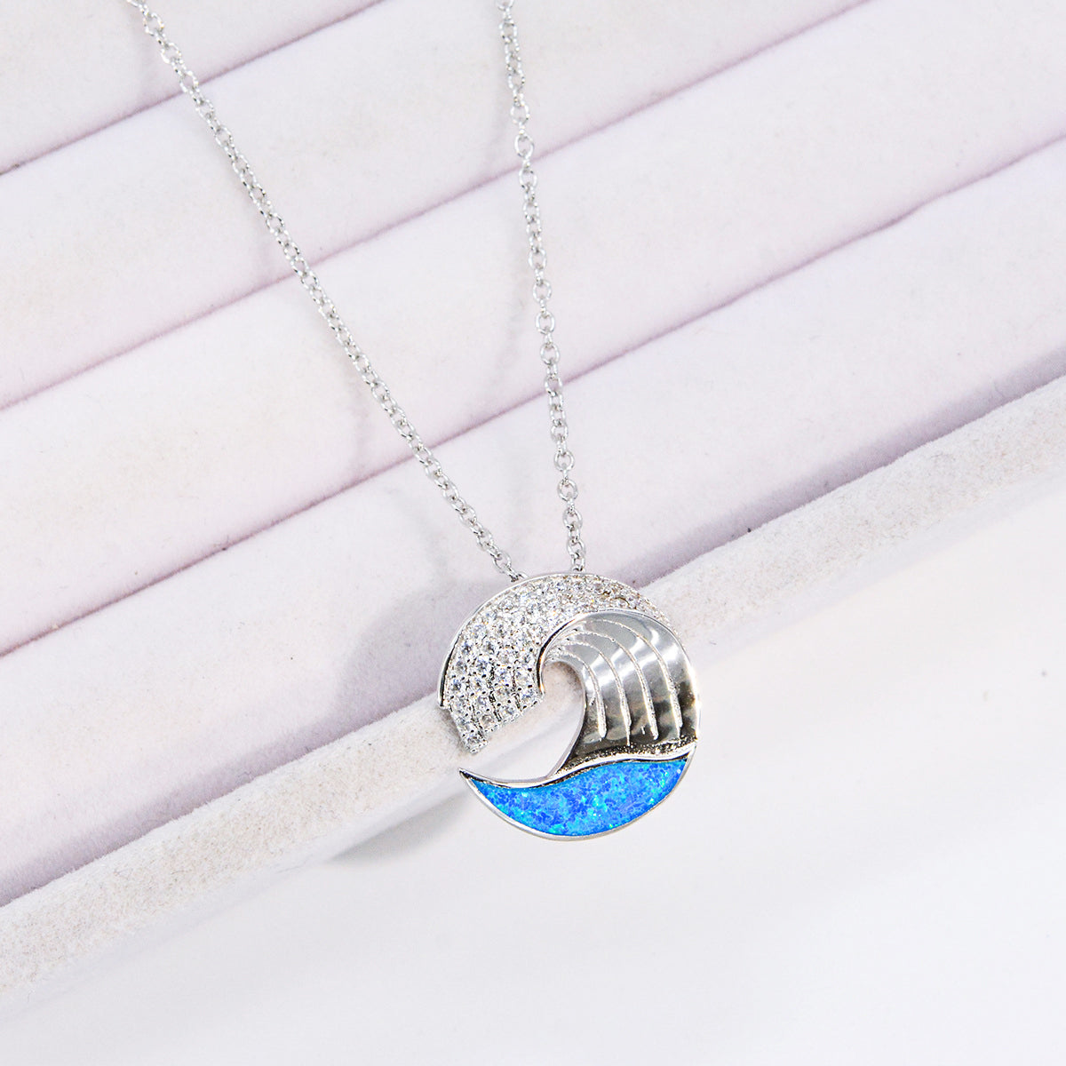 A stunning 925 sterling silver wave pendant necklace, intricately detailed with sea-blue opal and shimmering zircon stones, on a delicate silver chain.