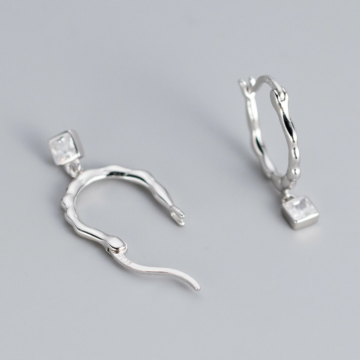 Elegant 925 sterling silver twisted hoop earrings with a sparkling square-cut zircon gemstone.