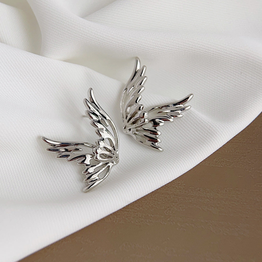 A pair of silver-plated hollow-out butterfly stud earrings with a polished finish, displayed on a clean white background. The intricate design resembles delicate butterfly wings.