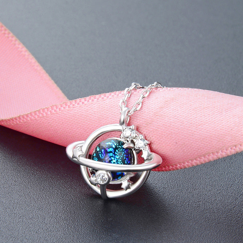 A detailed close-up of a 925 sterling silver necklace from a set of five, featuring a unique solar system pendant with a central blue gemstone.