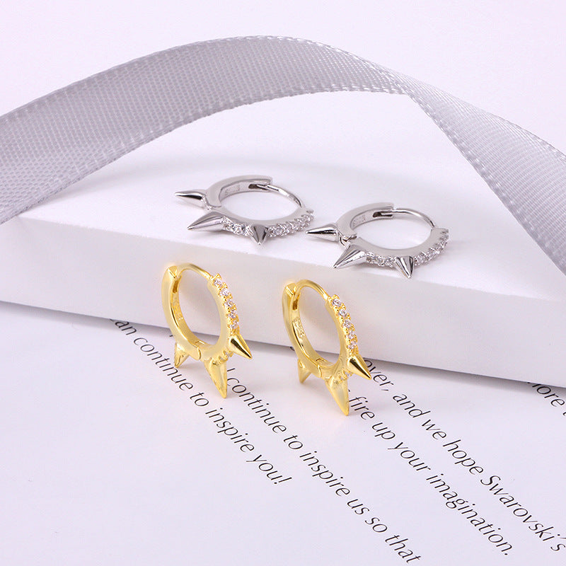 A pair of gold and a pair of silver 925 sterling silver rivet punk-style hoop huggie earrings displayed side-by-side on a white background.