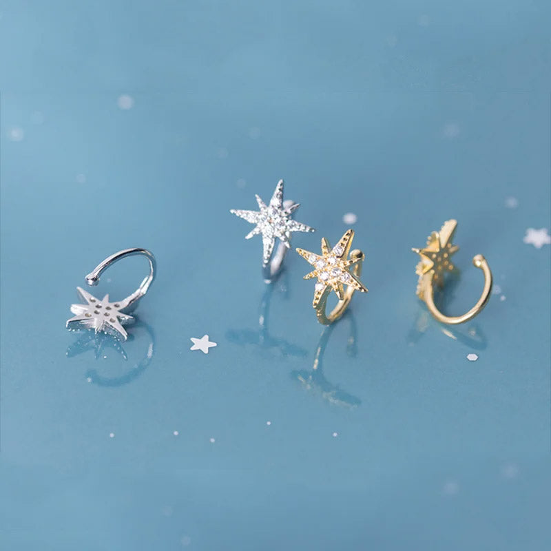 A set of four 925 sterling silver starburst ear cuff earrings with zircon stones, displayed in silver and gold finishes on a white background.