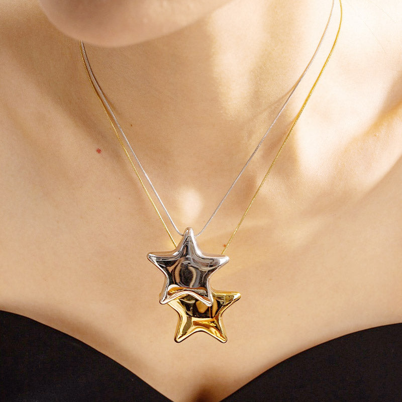 A model wearing layered waterproof PVD plated stainless steel star pendant necklaces, one in gold and one in silver, showcasing their elegant design.