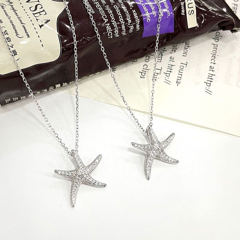 A pair of 925 sterling silver starfish necklaces from the set, featuring sparkling pave CZ stones on a white background.