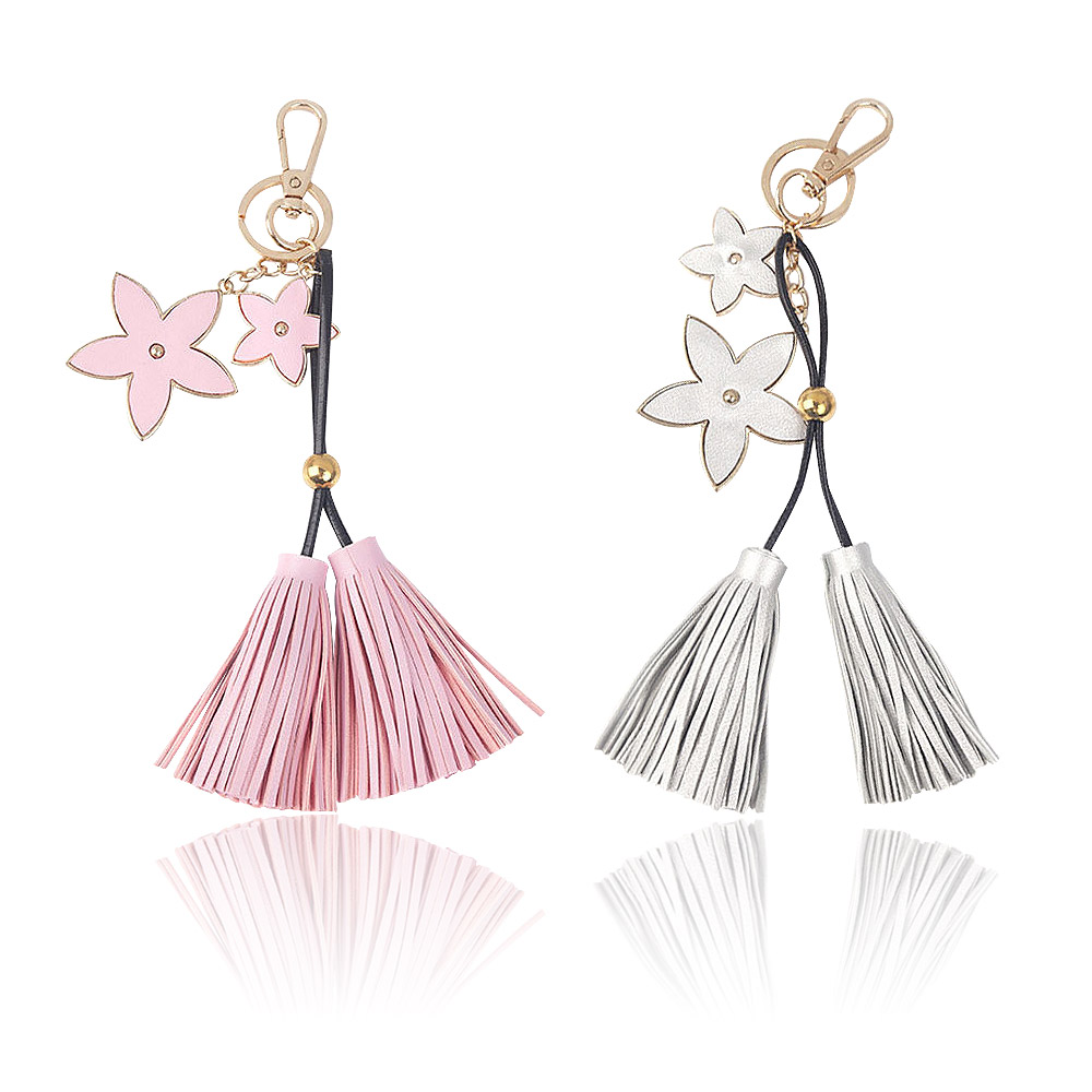 A pair of floral leather tassel keychains, one in pink and one in white, showcasing the customizable design and quality craftsmanship from JR Fashion Accessories.