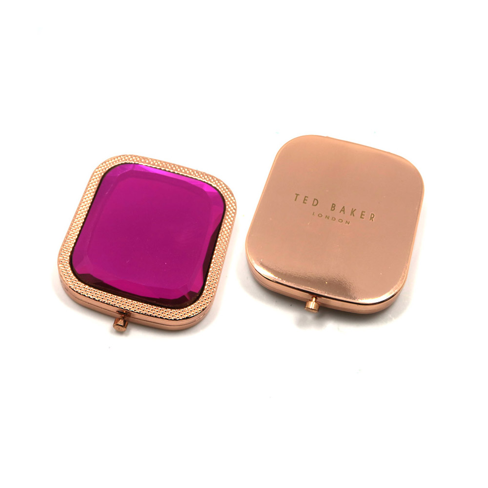 Elegant crystal gemstone pocket compact mirror in rose gold with a pink interior, featuring dual-sided magnification.