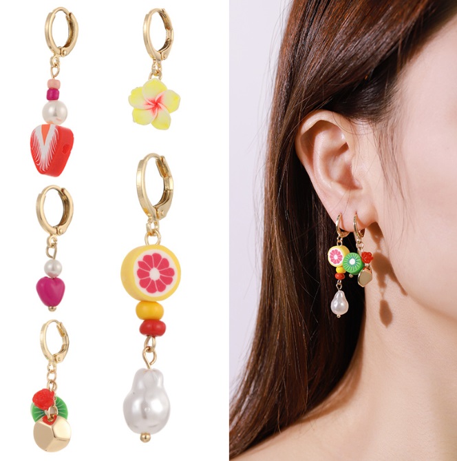 A vibrant set of soft clay tropical fruit earrings, showcasing the detailed design and how they look when worn.
