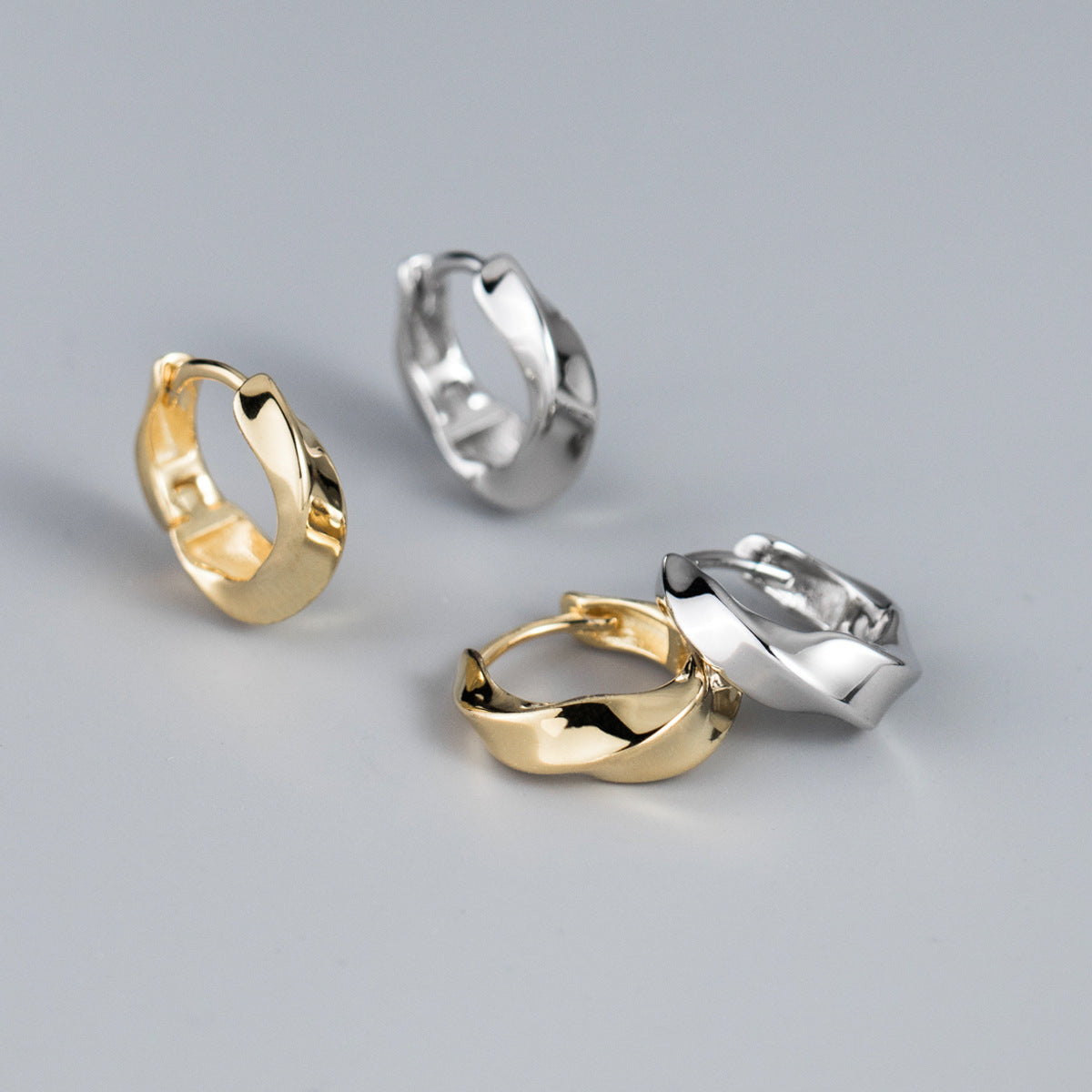 A set of four 925 sterling silver Mobius strip twist rope hoop earrings, two in a polished silver finish and two in a gold finish, displayed on a clean white background.