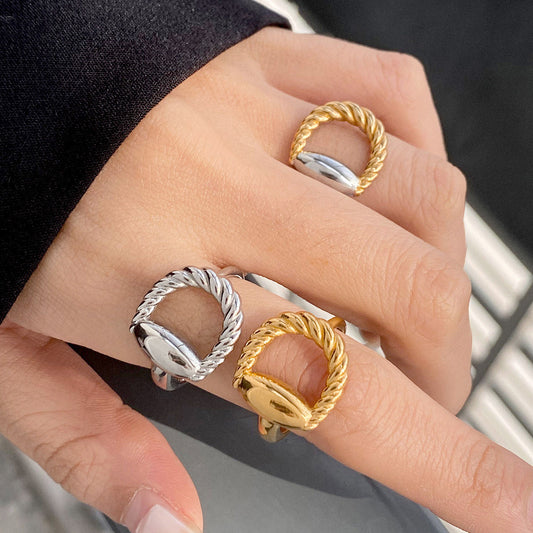 A model's hand showcasing a set of stylish twisted stainless steel rings from JR Fashion Accessories' wholesale collection.