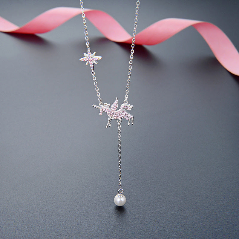 A delicate 925 sterling silver Y-chain necklace featuring a whimsical unicorn charm, a sparkling pink zirconia star, and an elegant drop pearl.