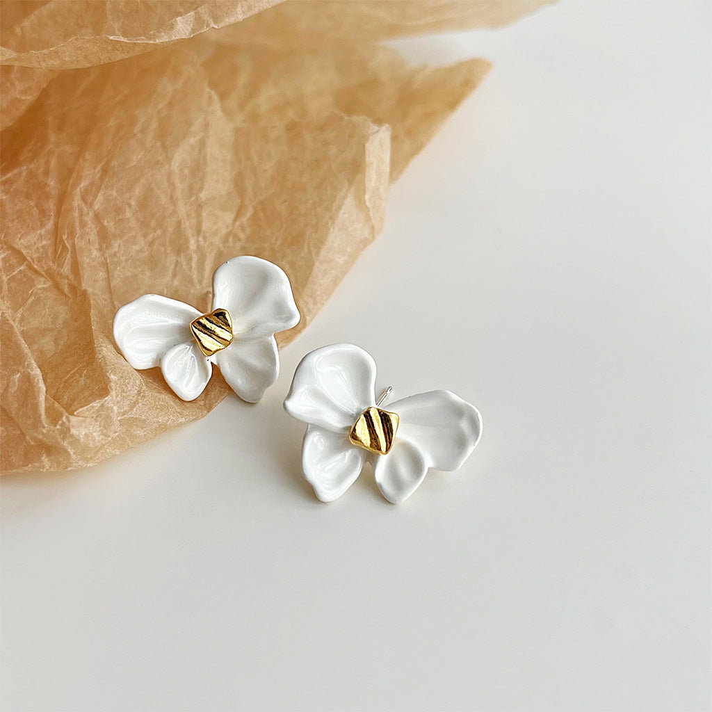 A pair of wholesale white enamel knot bow stud earrings with elegant gold plating, crafted from quality brass.