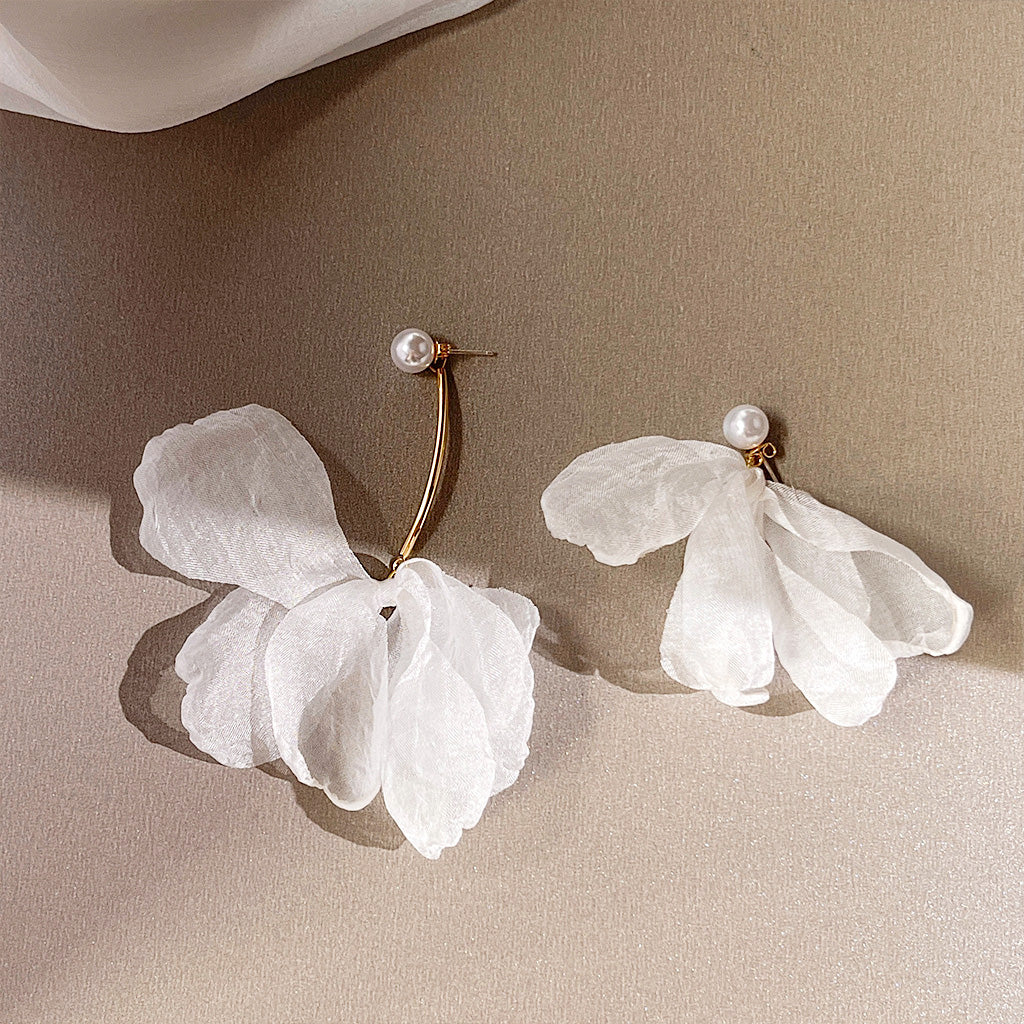 A detailed product shot of the vintage white lace flower asymmetrical pearl stud earrings, showcasing the delicate white petals, gold-finished brass, and elegant pearl accents.