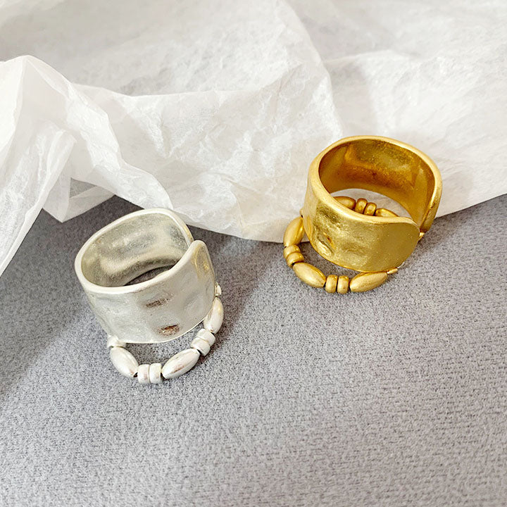 A pair of French-style two-layered open rings in gold and silver finishes, featuring elegant bead detailing on a white background.
