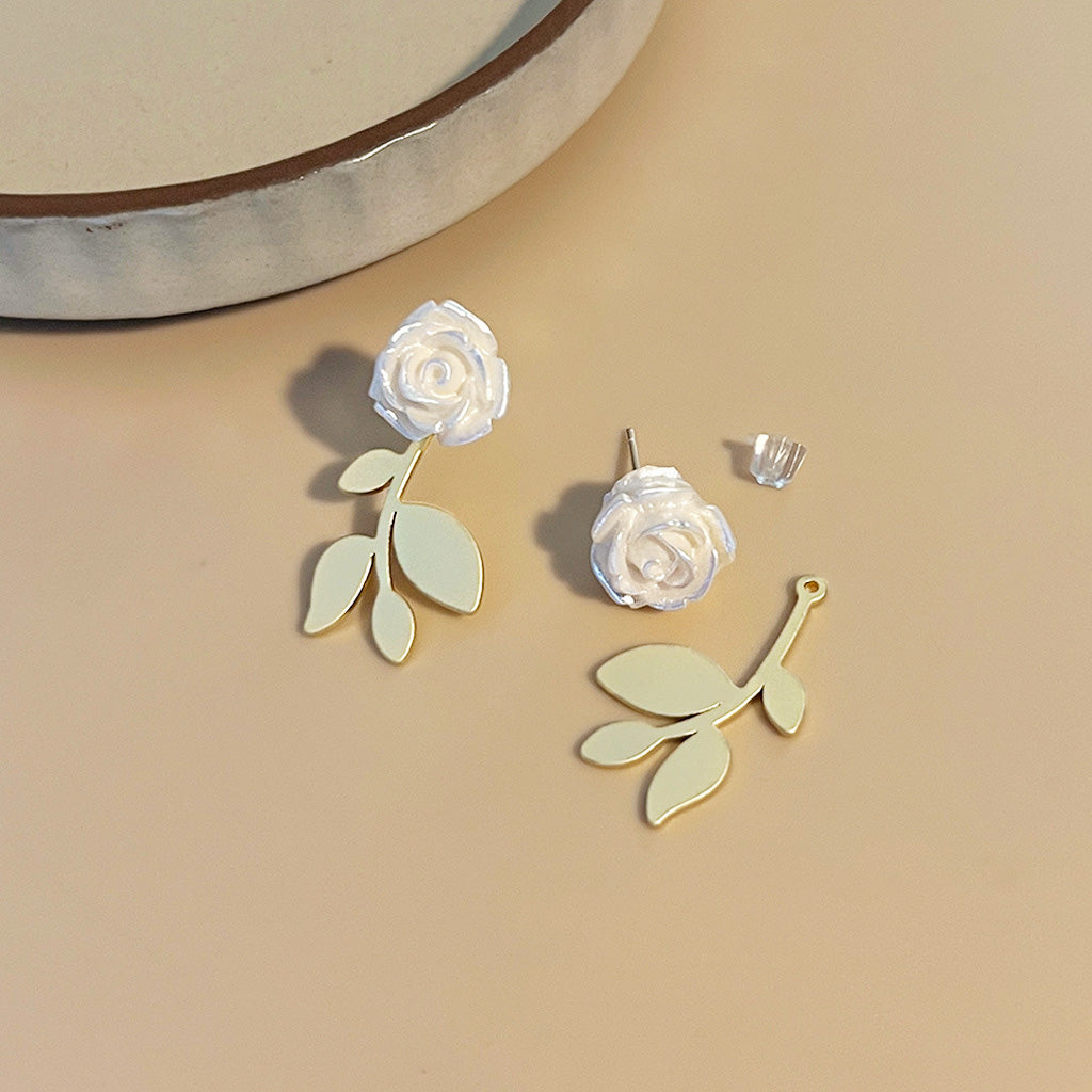 A pair of gold-plated stud earrings featuring a detailed 3D white rose flower design, shown against a clean white background.
