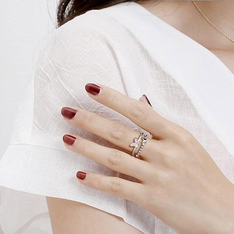 Model's hand showcasing the set of five 925 sterling silver adjustable rings, featuring intricate butterfly and zircon designs.