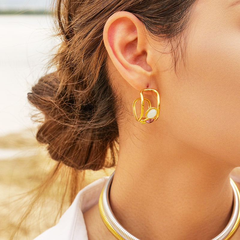 A close-up of a woman wearing the stainless steel Spanish-style stud earrings with three-color opal stones, showcasing their elegant look.