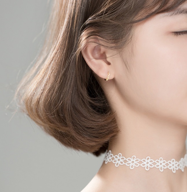 Model showcasing the elegant 925 Sterling Silver Mini Huggie Earrings, highlighting their delicate design and comfortable fit.