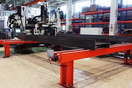 The optional transfer conveyor system is capable of cross transferring material like beams to be fed into or out from the fabrication area