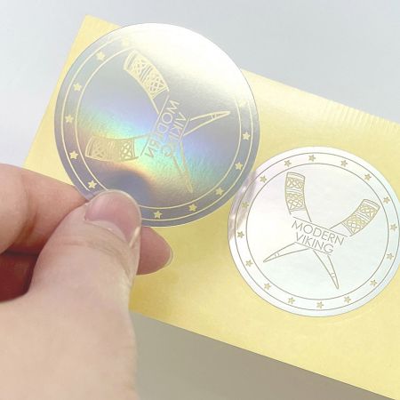 Gold foil stamped sticker on holographic paper