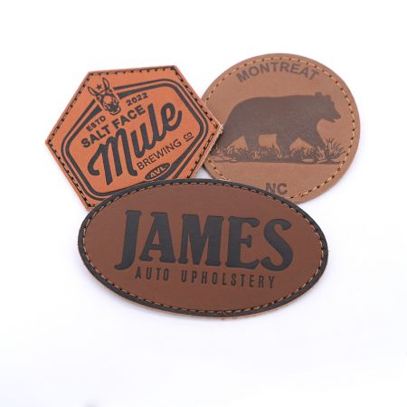 Patches de couro personalizados com design em relevo e fundo de velcro.