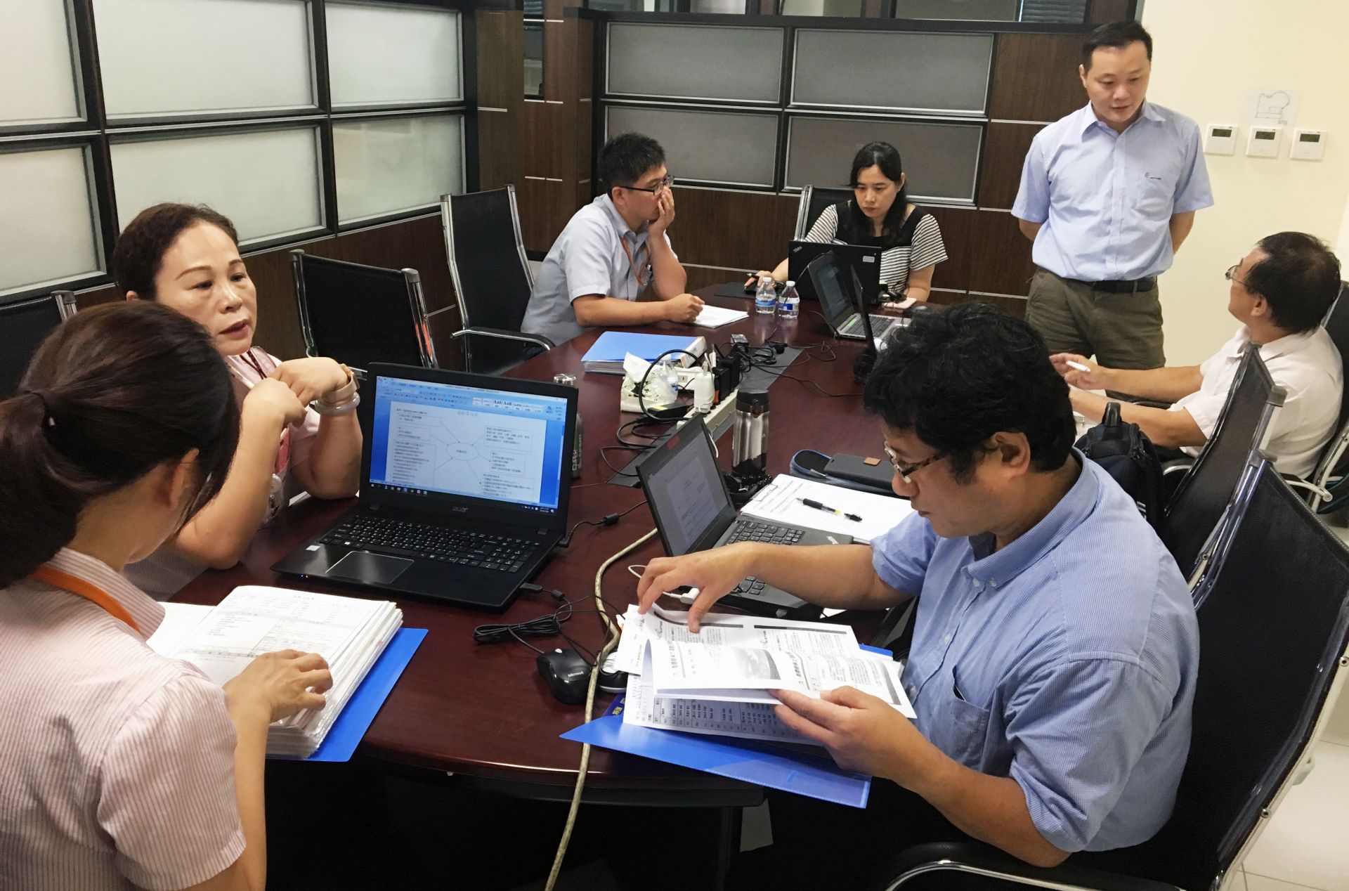 Três professores se concentram na auditoria em grupo