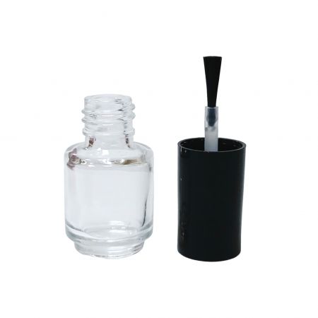 Botella de esmalte de uñas vacía y tapa de plástico con pincel