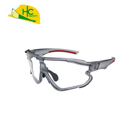 This is a pair of transparent safety glasses with red and black details, providing eye protection, suitable for use in the workplace or sports.