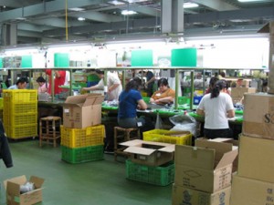 Tecnici che assemblano inverter da DC a AC sulla linea di produzione