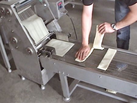Breaking a pile of wrappers with hands into three rectangular-shaped wrappers