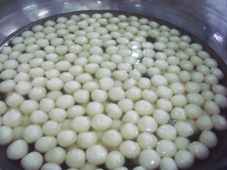 Chenna balls are submerged and cooked in sugar syrup.
