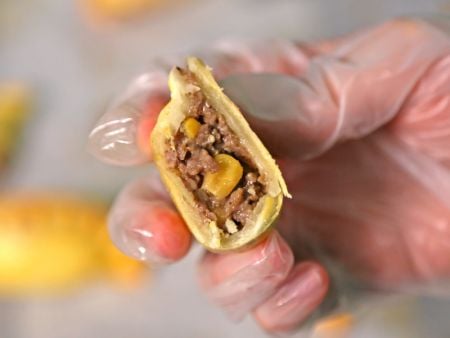 Les empanadas sont garnies d'ingrédients, y compris des grains de maïs entiers