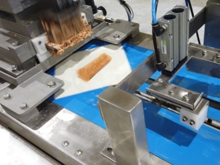 Filling is automatically extruded onto the wrapper