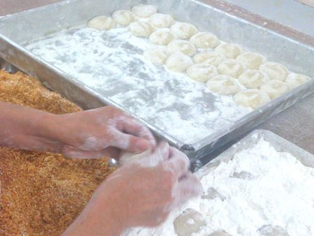 Bolinhos de arroz pegajosos feitos à mão requerem grandes quantidades de amido em pó para evitar que os produtos grudem