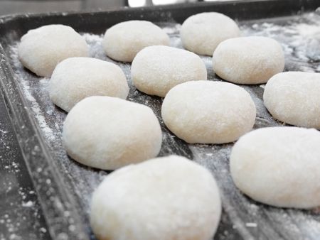 Mochis are placed on a tray and sprinkled with corn starch to prevent them from sticking
