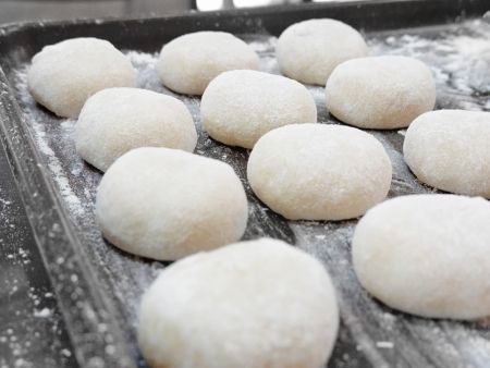 Mochi diletakkan di atas nampan dan ditaburi tepung jagung untuk mencegah menempel