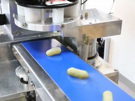 A máquina automaticamente molda a mistura em Bolinhas de Mandioca Recheadas