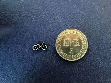經切割後精細的金屬腳踏車造型與五元硬幣對比