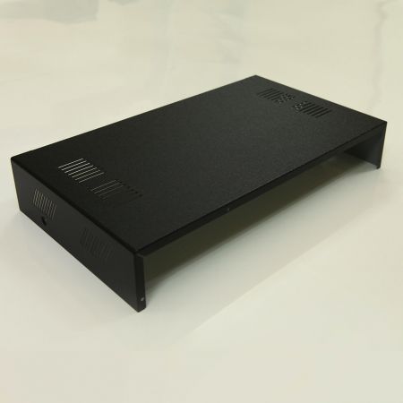 放置在白色桌面上，以黑亮皮紋素色PVC覆膜金屬裝飾表面的電腦機殼遠景