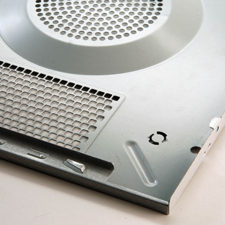 Detailní fotografie počítačové skříně s kovovou texturou, která je zdobená šampaňským stříbrem laminovanými kovovými deskami na povrchu