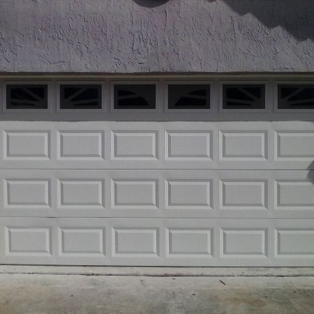 使用雪花白素色PVC覆膜金屬鋼板裝飾表面的車庫捲門正面