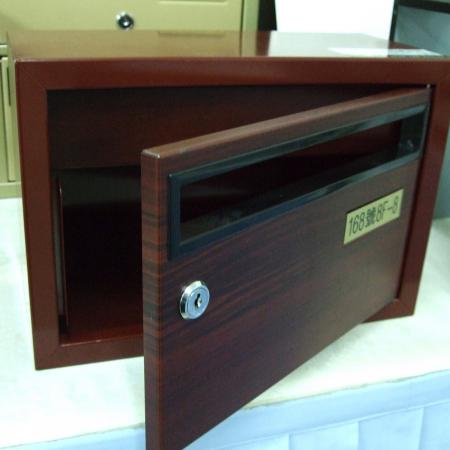 A metal mailbox with a red cherrywood grain laminated metal surface, with the mailbox door open