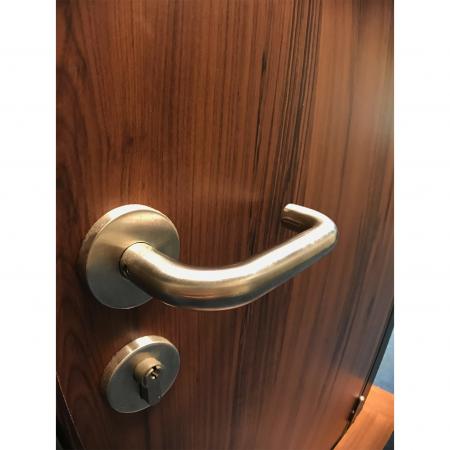 Close-up van brandwerende deurgreep met taxushout PVC-gelamineerde metalen plaat als oppervlakteversiering