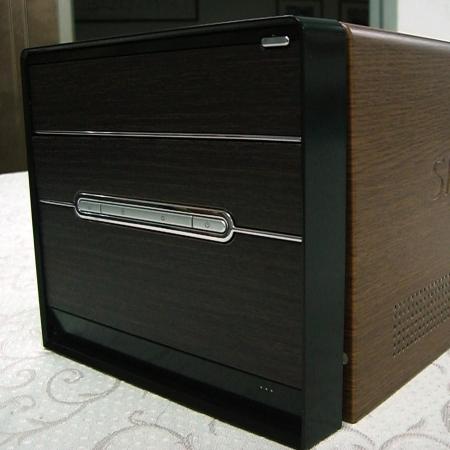 표면을 장식하기 위해 갈색 호두 무늬 적층 금속판을 사용한 컴퓨터 케이스의 근거리 측면 보기