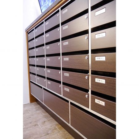 Крупный план правой стороны роскошного почтового ящика в здании, украшенного металлическими пластинами с ламинированным ПВХ и зернистой текстурой кассод