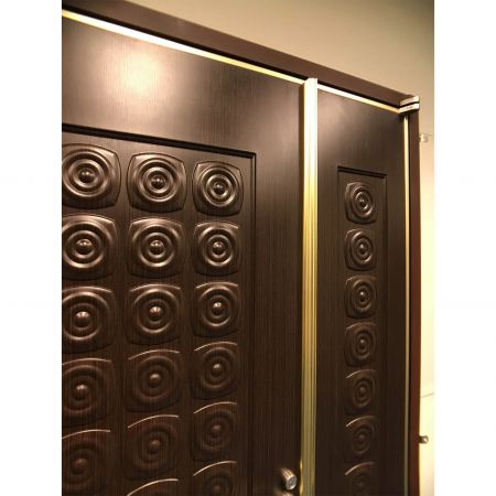 Увеличенный вид передней части огнестойкой двери, украшенной металлическими пластинами с ПВХ-ламинацией в зернистом стиле Kassod