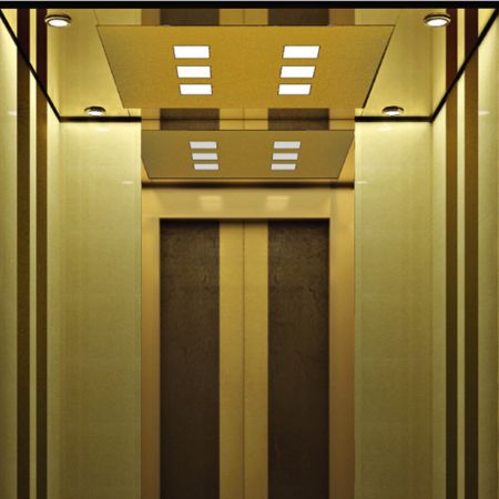 ドアが開いているエレベーターの正面ビューで、クラシックな装飾があります。エレベーターキャビンの壁の一部は真鍮フリーズのラミネート金属プレートで装飾されています。