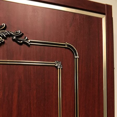 Pohled zblízka na klasický dveřní panel zdobený PVC laminovanou kovovou deskou s B103 Redwood dřevěným vzorem