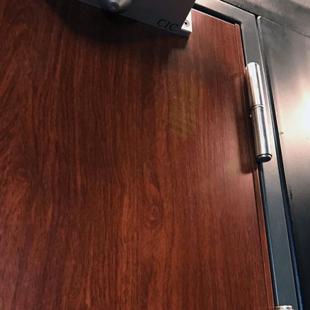 Vista ravvicinata di un pannello porta moderno decorato con lamiera metallica laminata con film PVC grano Redwood
