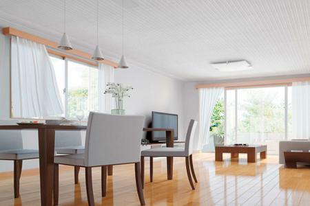 Et enkelt og lyst stue bruker et tak laget av enkelt belagt metall og et tregulv.