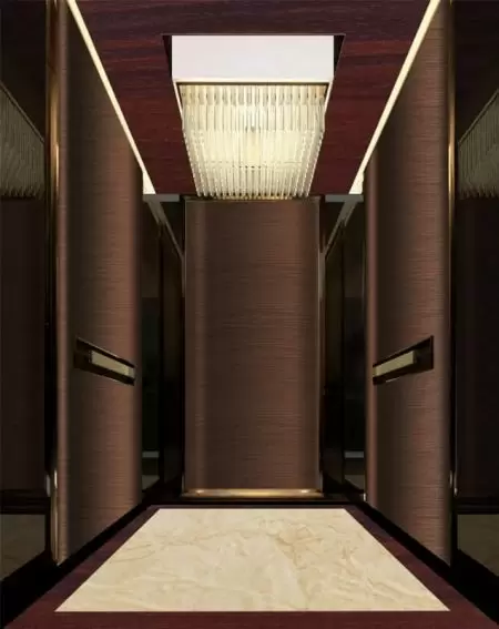 Mur d'ascenseur décoré de plaques d'acier laminé métallique avec grain de bois de cerisier rouge et plaques en acier inoxydable anti-empreintes de rose doré.